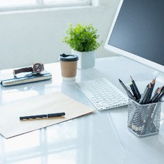 glänsande skrivbord med tangentbord, pennhållare och ett pappersark
